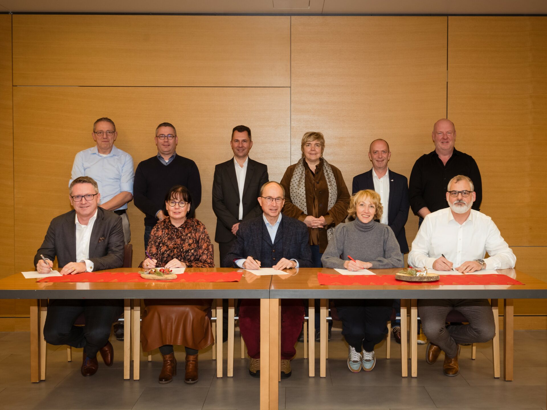 Groupe de personnes qui signe un accord